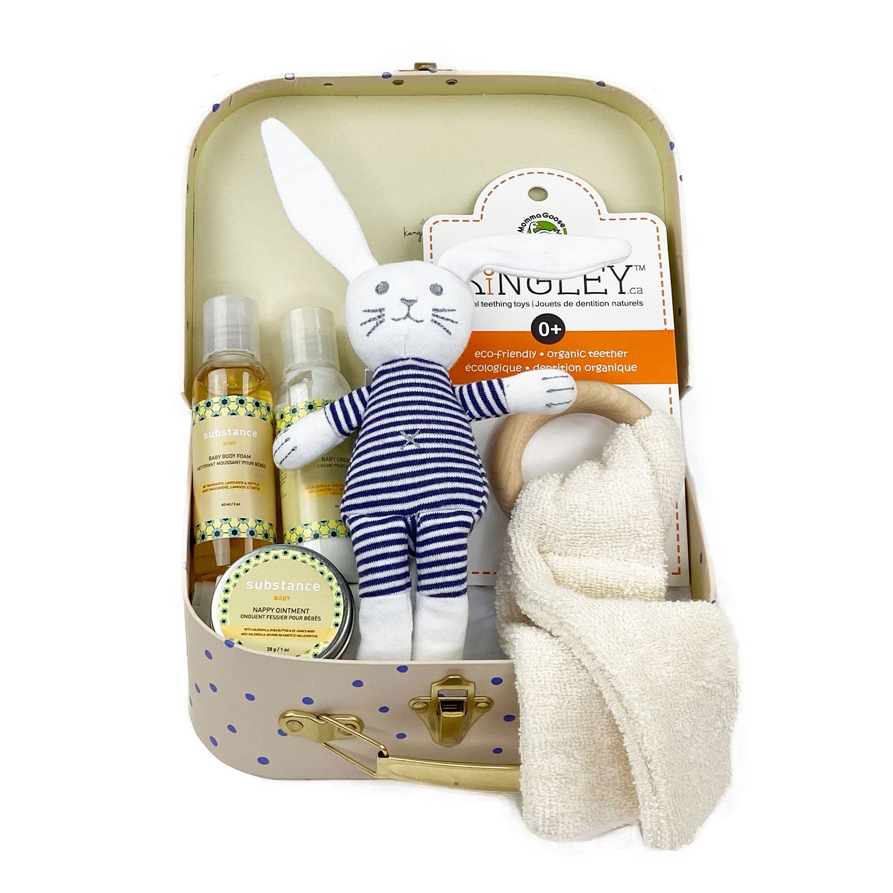 Gender neutral baby gift box featuring a bunny rattle, a terry teether and a travel size of baby skin care presented in Konges Luggage