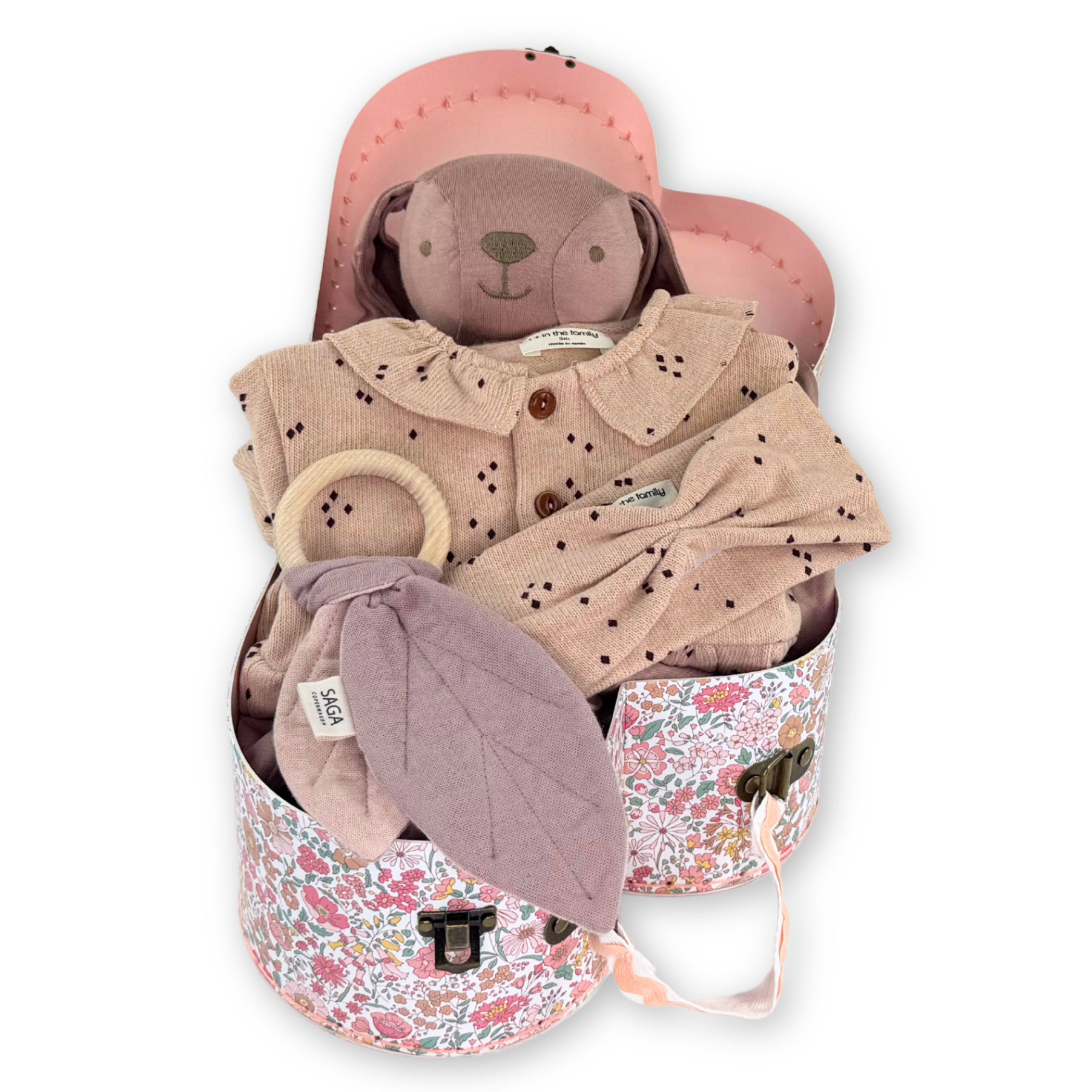 Baby gift set with pink teddy bear, outfit, and hat in a floral container 