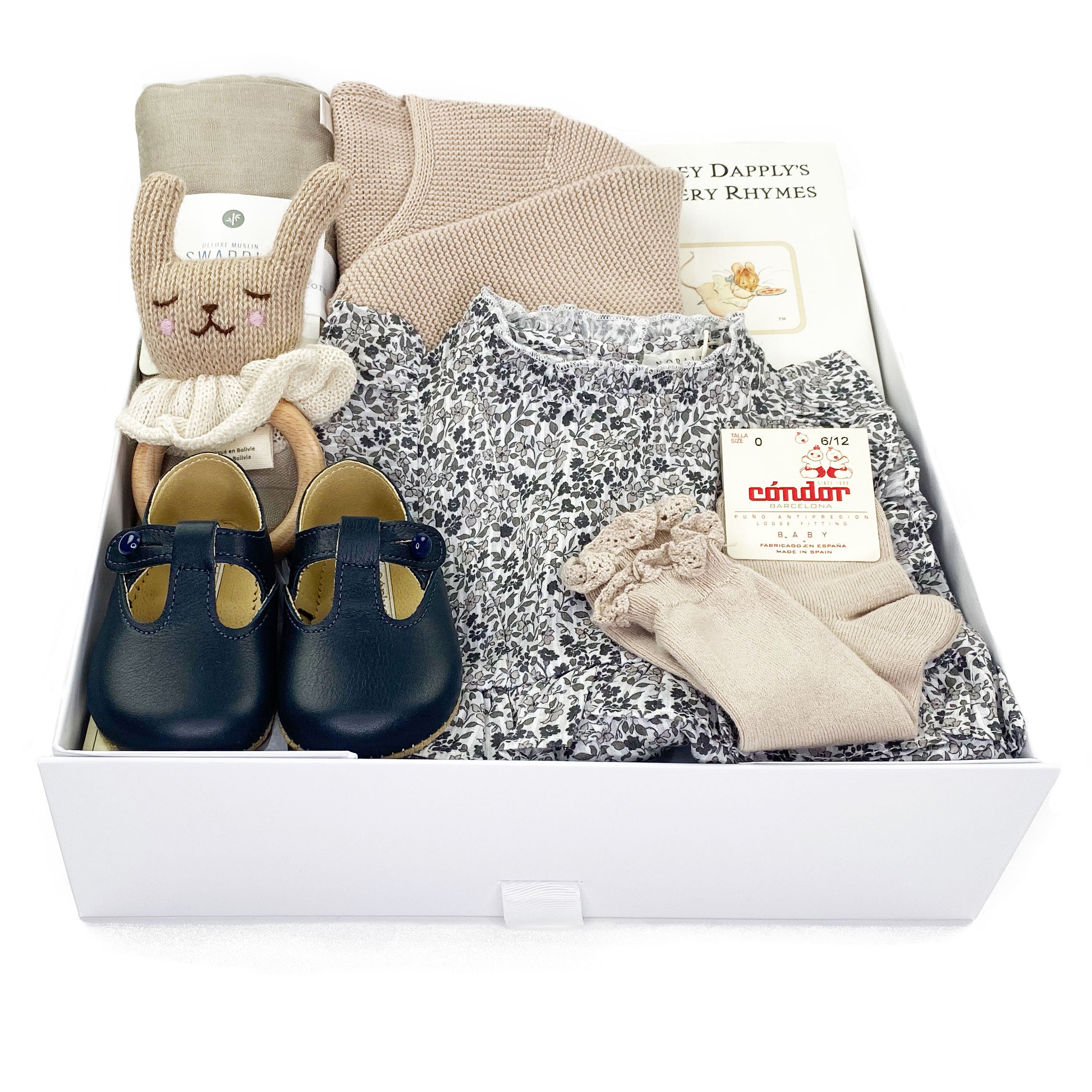 Luxury Gift Box featuring Noralee romper in blue flowers print, leather shoes by Early Days, cotton socks and bolero sweater by Condor and luxury curated baby gifts. 