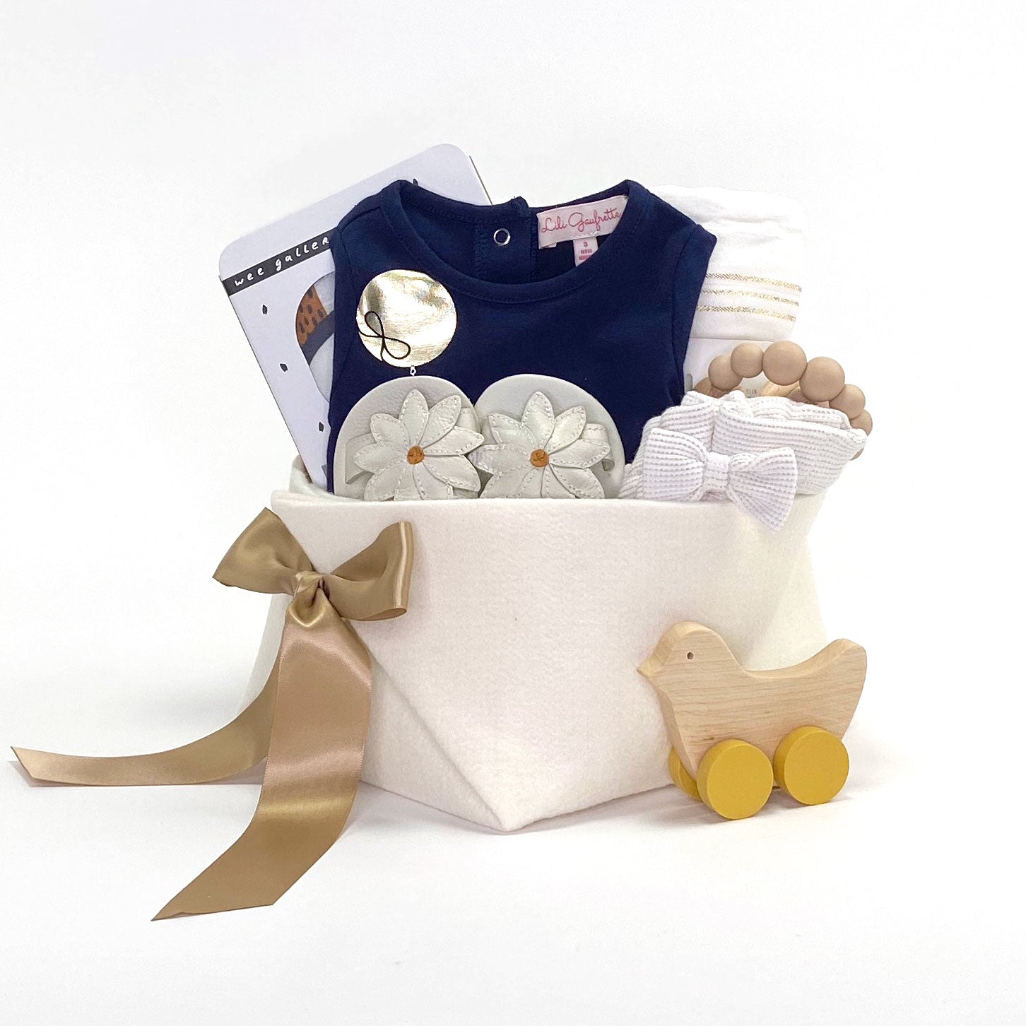 Luxury Baby Girl Gift Basket at Bonjour Baby Baskets featuring a lovely top and shorts with a little bit of gold, leather sandals and curated accessories that parents would love. 
